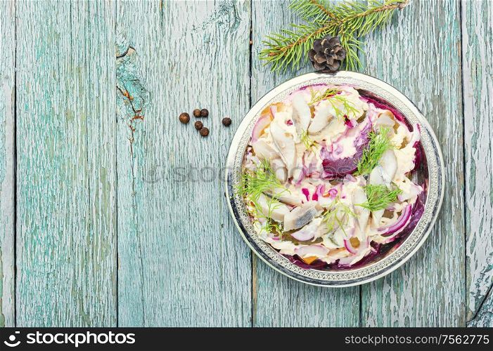 Appetizing salad with herring and vegetables.Seafood salad.Traditional Ukrainian salad.Russian cuisine.Space for text. Christmas salad with herring