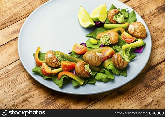 Appetizing salad with spinach, tomato, pepper and snails.. Salad with vegetables and snails