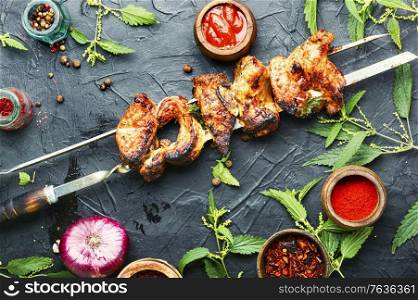 Appetizing shashlik on skewers with nettle marinade.. Kebabs,grilled meat with nettles
