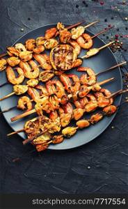 Appetizing shrimps roasted on a wooden skewer. Grilled prawn. Grilled shrimp on a skewer