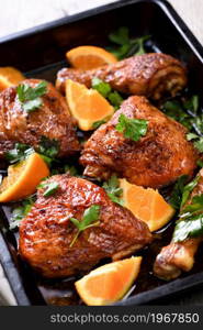 appetizing slices of baked chicken with crispy fried crust and oranges in a baking sheet