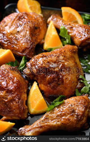 appetizing slices of baked chicken with crispy fried crust and oranges in a baking sheet