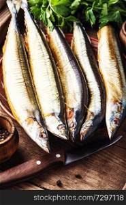 Appetizing smoked fish on kitchen board.Smoked saury.Smoked fish with spices. Smoked sanma or pacific saury