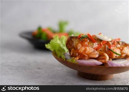 Appetizing Spicy Canned Sardine salad with spicy sauce in wood bowl