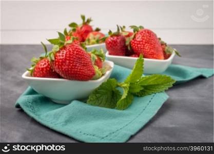 Appetizing strawberry in the bowl on a black slate table top.