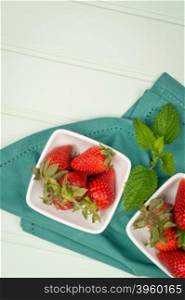 Appetizing strawberry in the bowl on a wooden background.