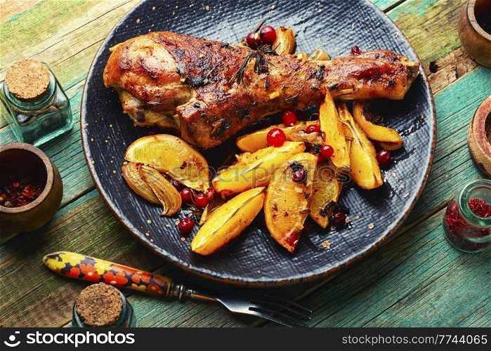 Appetizing turkey leg fried with oranges and spices. Turkey leg with orange