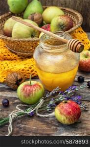 apple and honey. Autumn harvest of apples in the background of the glass jar with fragrant honey.Photo tinted