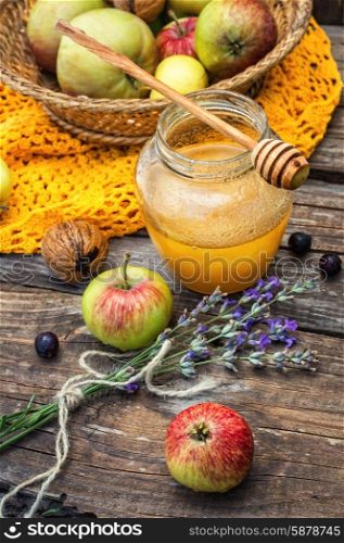 apple and honey. Autumn harvest of apples in the background of the glass jar with fragrant honey.Photo tinted