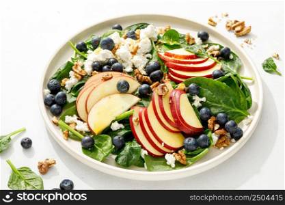Apple and spinach fresh sweet fruit salad with blueberry, cheese cottage and walnuts