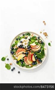 Apple and spinach fresh sweet fruit salad with blueberry, cheese cottage and walnuts, top view