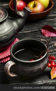 Apple autumn tea. clay kettle with tea and the autumn harvest autumn apples