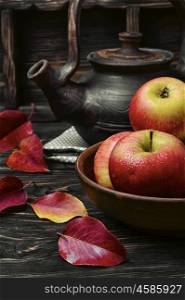 Apple autumn tea. clay kettle with tea and the autumn harvest autumn apples