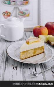 Apple cheesecake and tea pot on wooden table