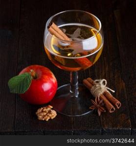 apple cider still life with cinnamon stick, apple, walnut, and anise star