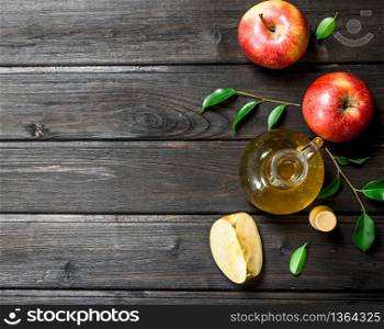 Apple cider vinegar with fresh apples. On wooden background.. Apple cider vinegar with fresh apples.