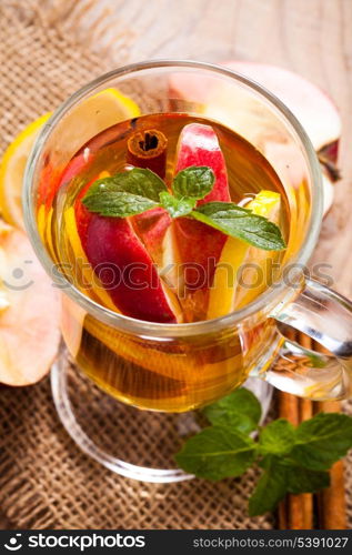 Apple, cinnamon and citrus beverage with twig of mint