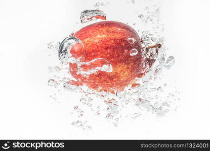 Apple falls under water with a splash. With lots of air bubbles