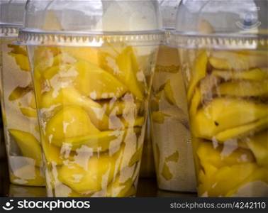 apple-fruit salad. fruit salad in plastic cups on a wooden table