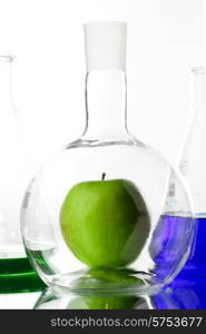 Apple in chemistry beaker in laboratory, gmo concept