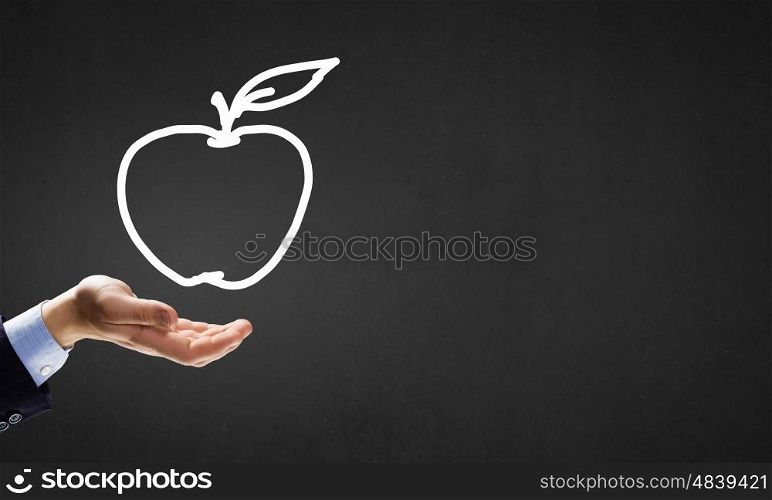 Apple in hand. Human hand holding apple drawn symbol in palm