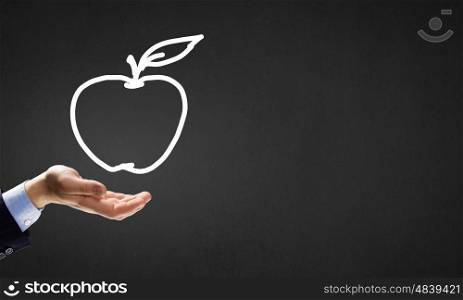 Apple in hand. Human hand holding apple drawn symbol in palm