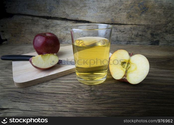 Apple juice and apples on a wooden table