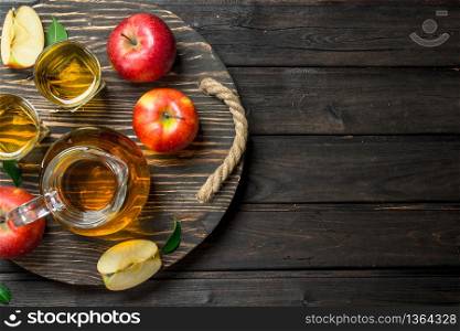 Apple juice in a glass decanter on a wooden dressing with fresh apples. On wooden background.. Apple juice in a glass decanter on a wooden dressing with fresh apples.