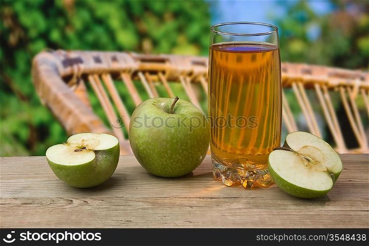 apple juice on a wooden table in the garden