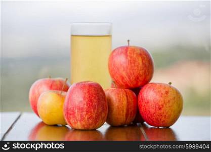 apple juice with apples on a wooden table, outdoor
