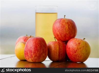 apple juice with apples on a wooden table, outdoor