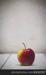 Apple on white wooden background with copyspace