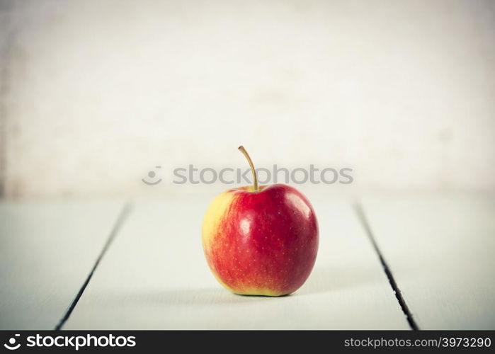 Apple on white wooden background with copyspace. Apple on white wooden background, space for text