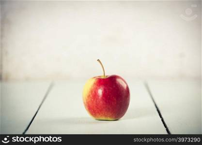 Apple on white wooden background with copyspace. Apple on white wooden background, space for text