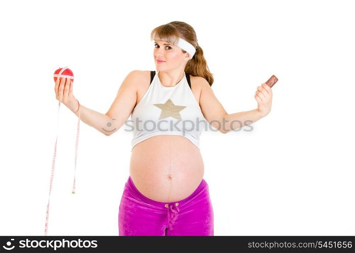 Apple or chocolate? Beautiful pregnant woman making choice isolated on white&#xA;
