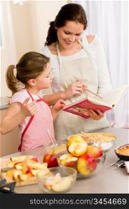 Apple pie mother and daughter follow recipe from baking cookbook