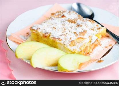 Apple pie on plate with spoon, pink placemat on background