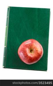 Apple red on a green book seen from above a over white background