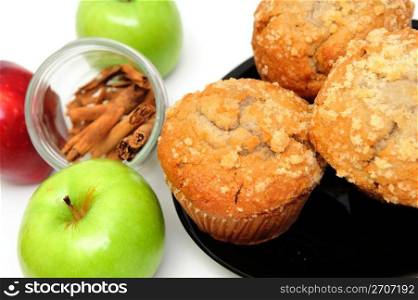 Apple Spice muffins on a white background with 2 green granny smith, one red apple and cinnamon sticks. Apple Muffins