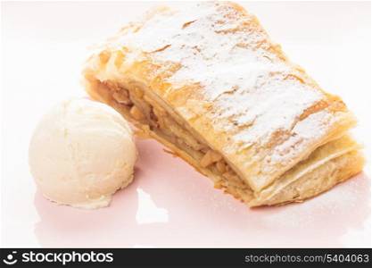 Apple strudel and ice cream ball on a pink plate