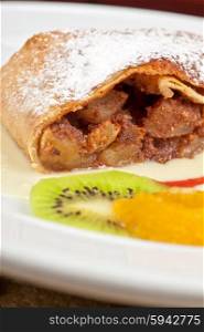 Apple strudel closeup. Apple strudel with fruits and sauce