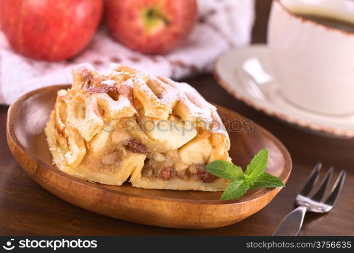 Apple strudel with raisins with coffee (Selective Focus, Focus on the left side of the apple-raisin stuffing)