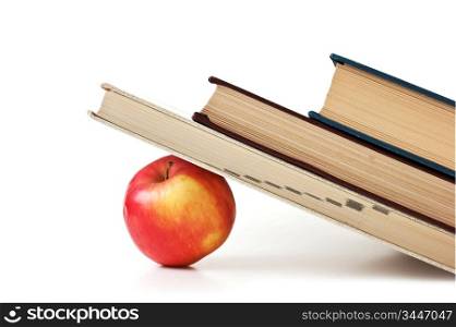 apple under a pile of books isolated on white