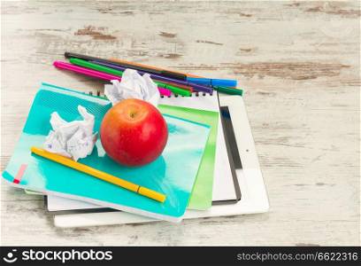 Apple with school supplies on aged white wooden table. Apple with school supplies