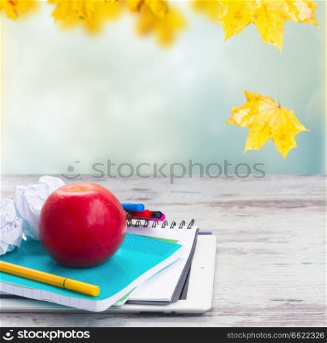 Apple with school supplies on white aged wooden table. Apple with school supplies