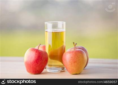 apples and apple juice on a wooden table, outdoor