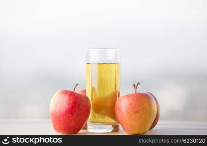 apples and apple juice on a wooden table, outdoor