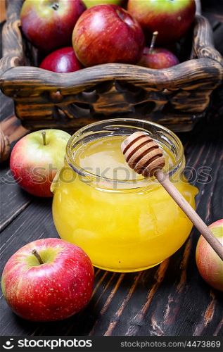 Apples and honey. jar of honey and wooden basket of apples