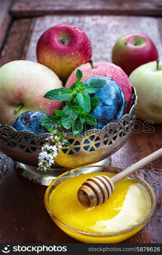 apples and plums in iron vase. apples and plums in iron vase and saucer with fresh honey