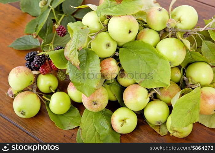 apples and raspberries on a wooden table